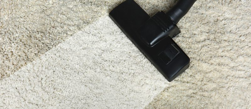 close-up view of cleaning white carpet with professional vacuum cleaner